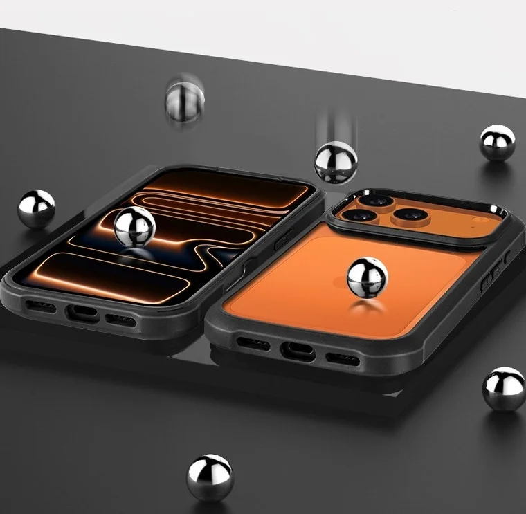 黒い保護ケースに収められた2台のスマートフォンが、暗く反射する表面に置かれ、周囲には複数のメタリックボールが散らばっています
