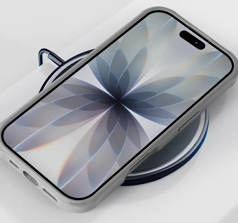 ライトグレーのスマホケースに入ったスマートフォンが、ワイヤレス充電器またはマグネットスタンドの上に置かれている