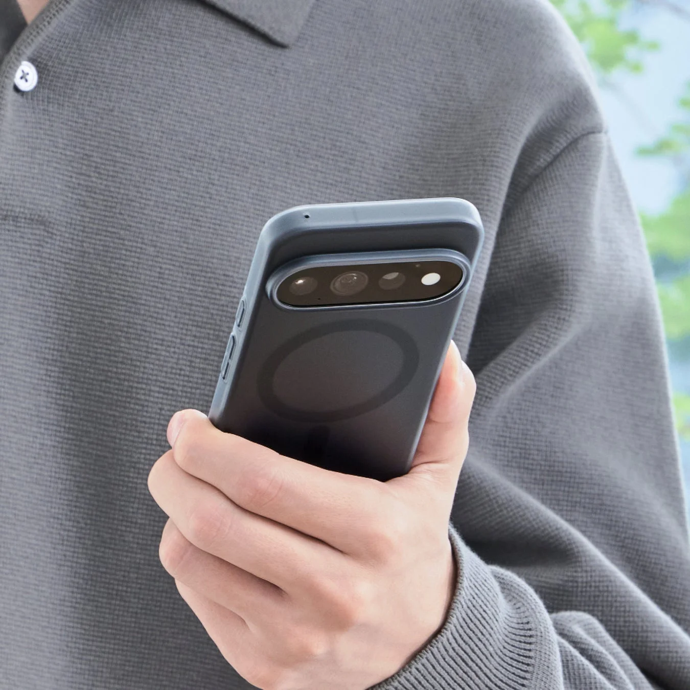 複数のカメラレンズとMagSafe対応のリングが見える黒いスマートフォンケースを装着したスマートフォン
