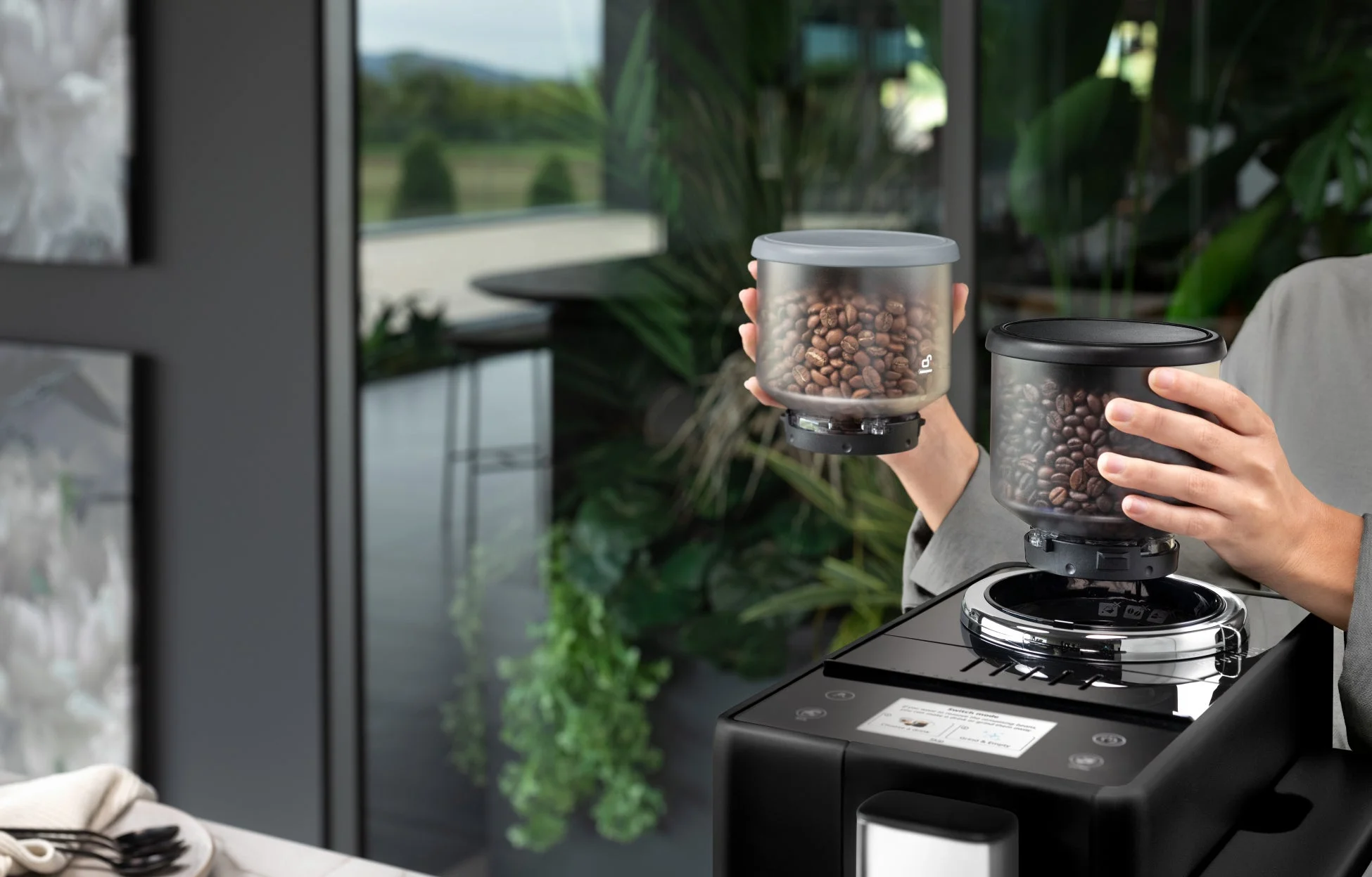 全自動コーヒーメーカーにコーヒー豆の容器をセットしている手元
