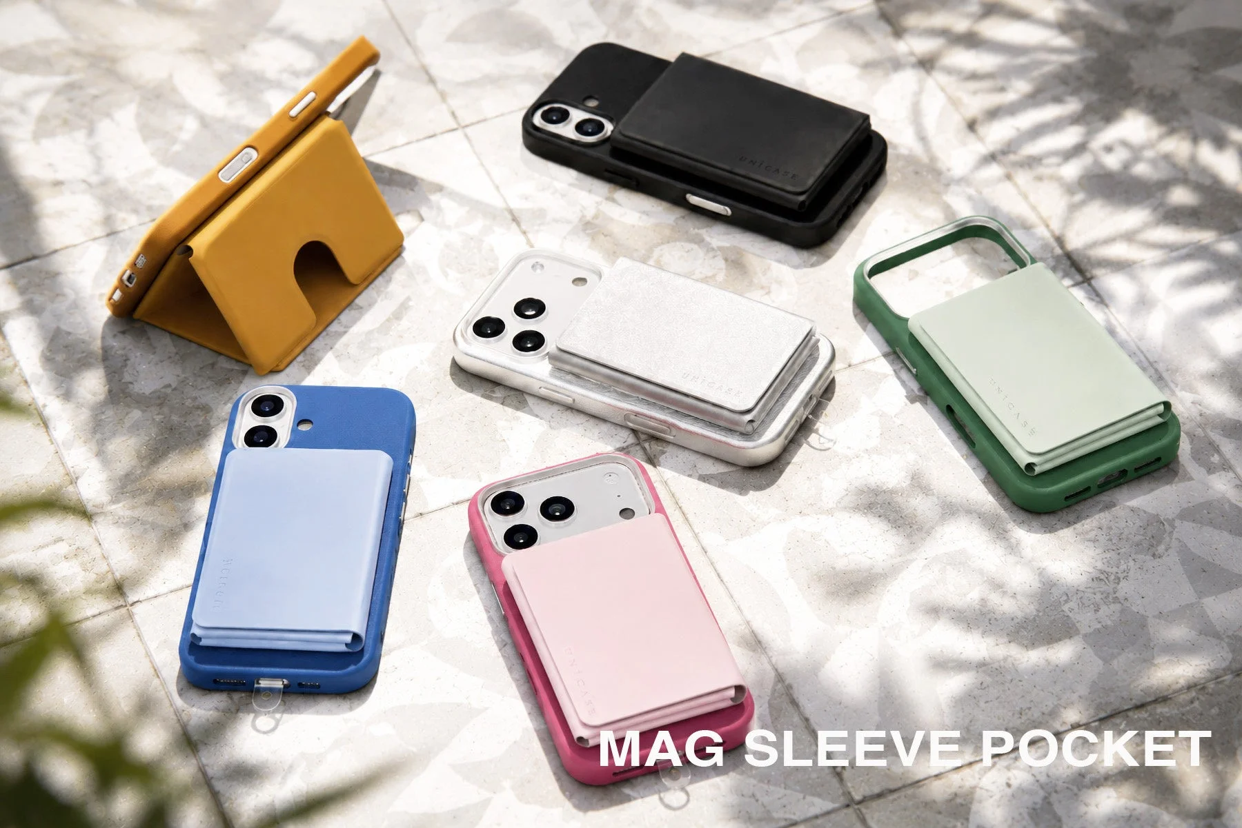 様々な色のスマートフォンケースと、マグネットで装着できるウォレット型カードホルダーが複数並べられています