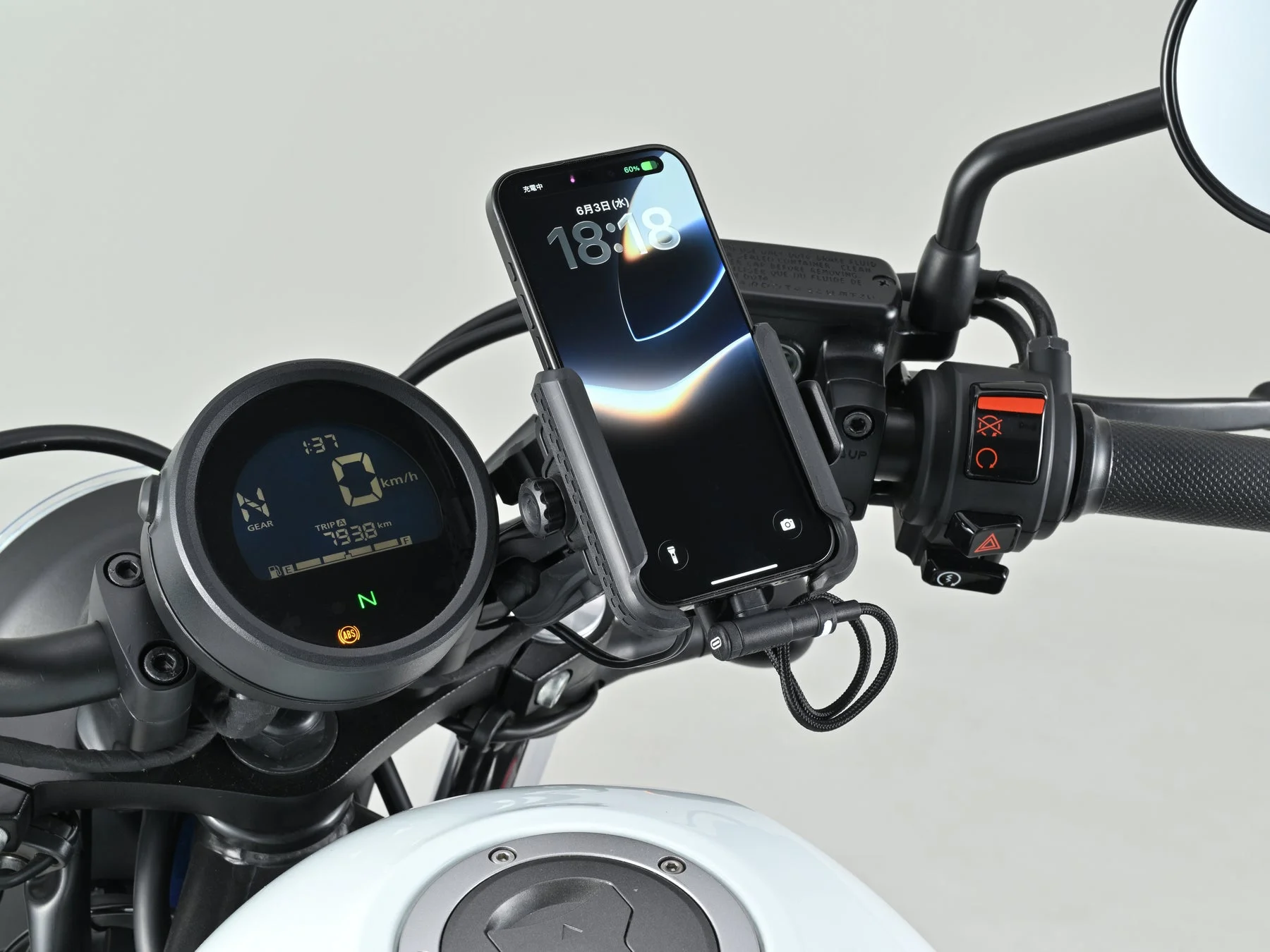 バイクのハンドル部分にスマートフォンが装着され充電されている様子