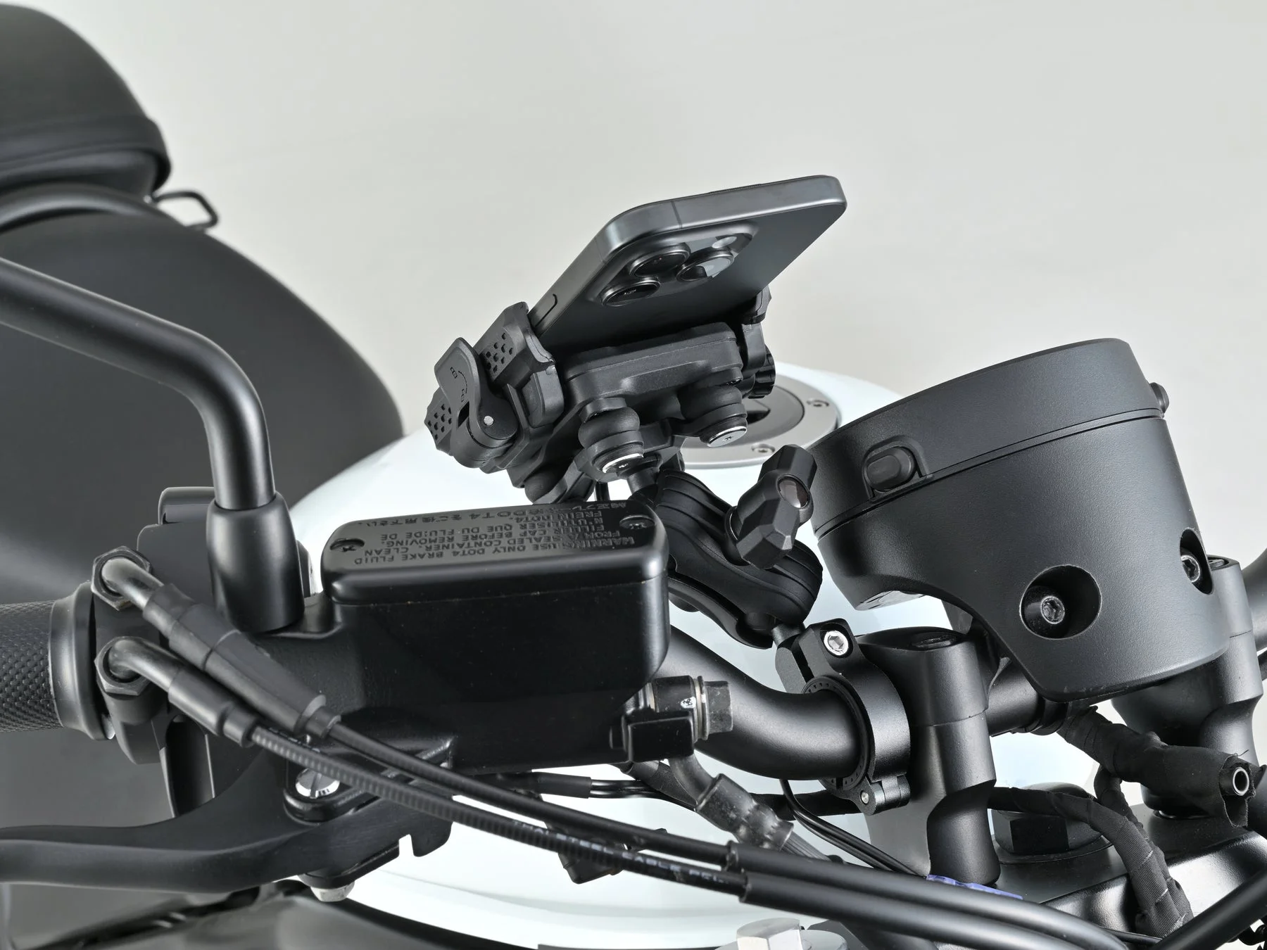 バイクのハンドル部分にスマートフォンが専用ホルダーで取り付けられている様子